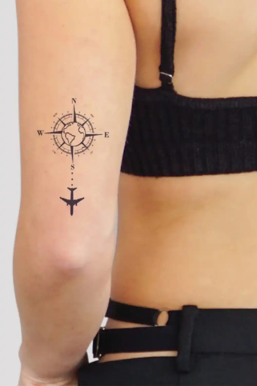 Back of an upper arm with a compass and globe tattoo above an airplane, EasyTatt semi permanent tattoo