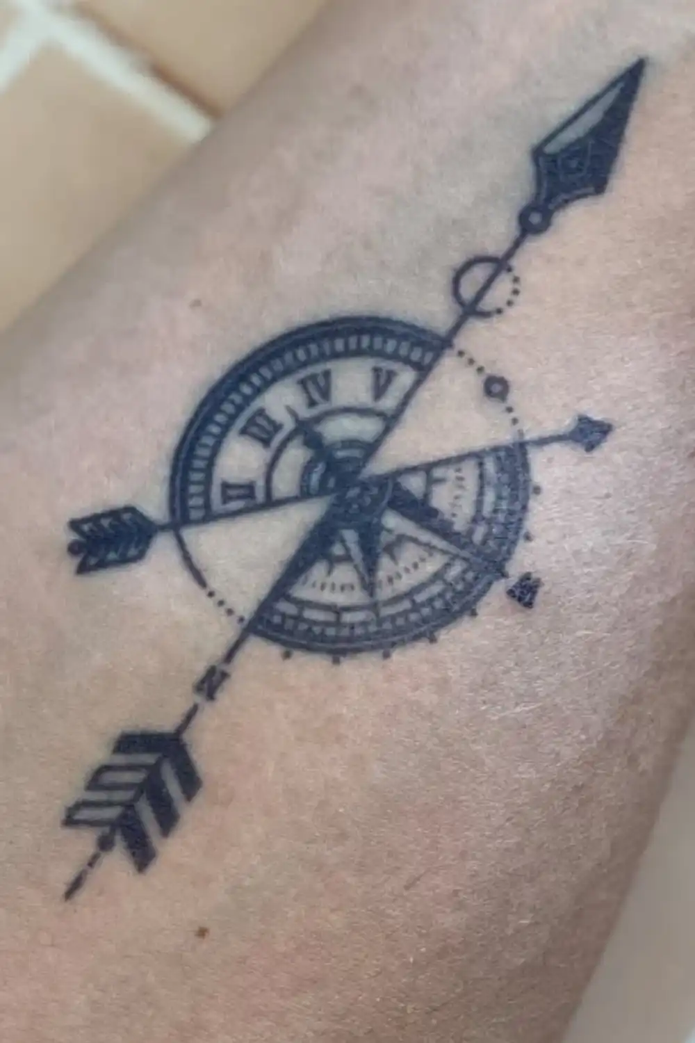 Close-up of an EasyTatt temporary tattoo featuring a vintage compass with Roman numerals and an intersecting arrow design