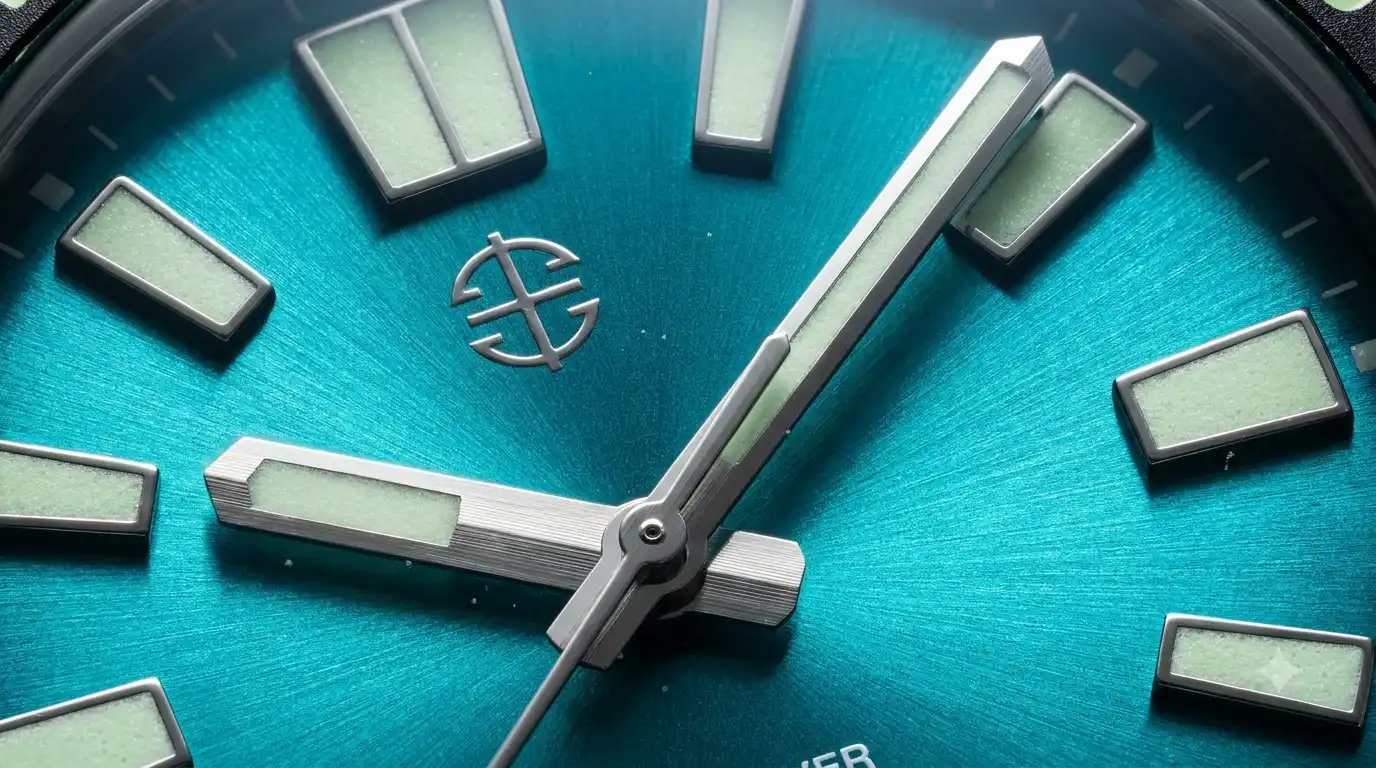 Aethelsohn Ocean Crest Sunburst Aqua dial close-up showing sunray pattern and lume hands